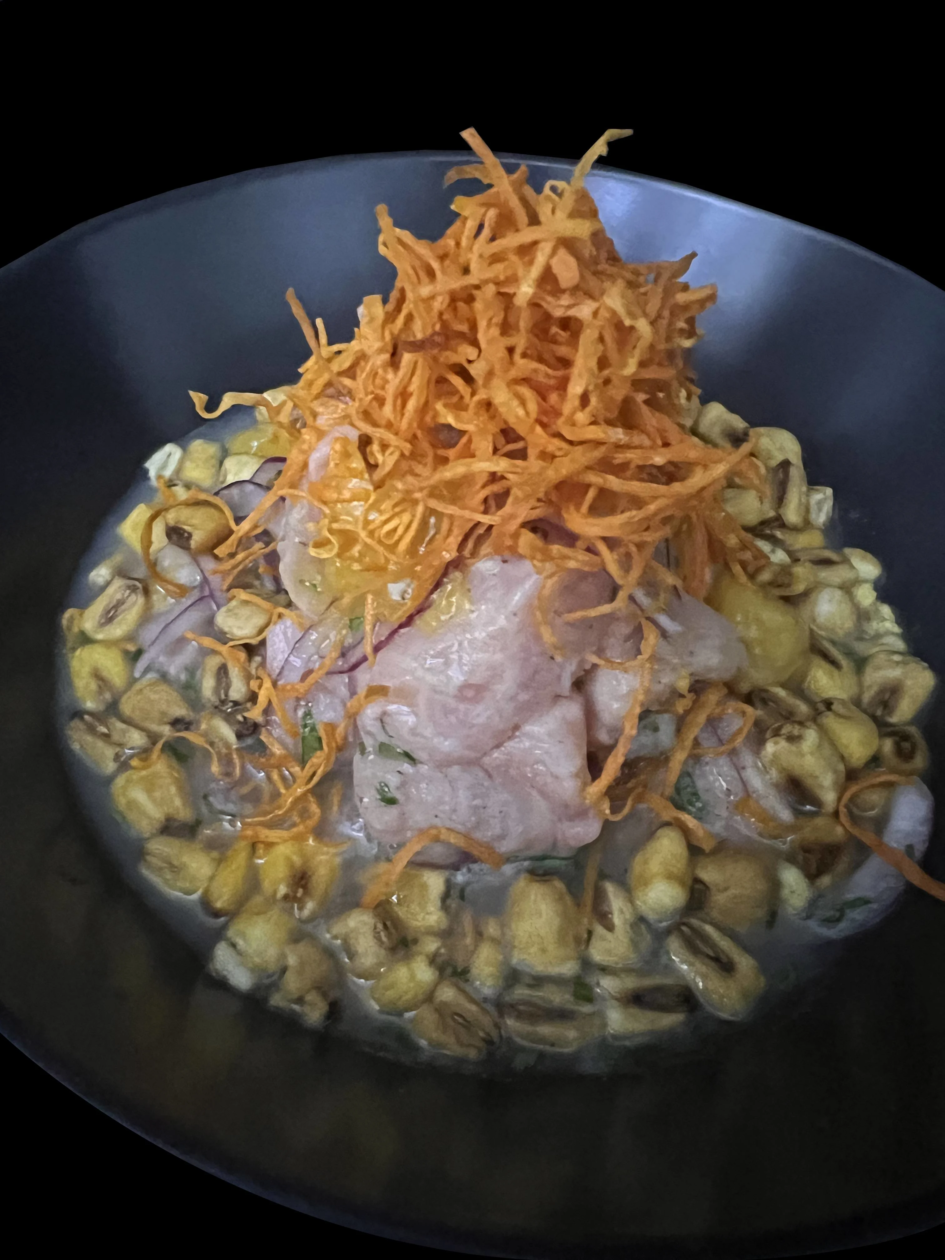 Cubos de salmón y mango con leche de tigre,camote, cebolla morada, cilantro, chips de boniato y maíz cancha.