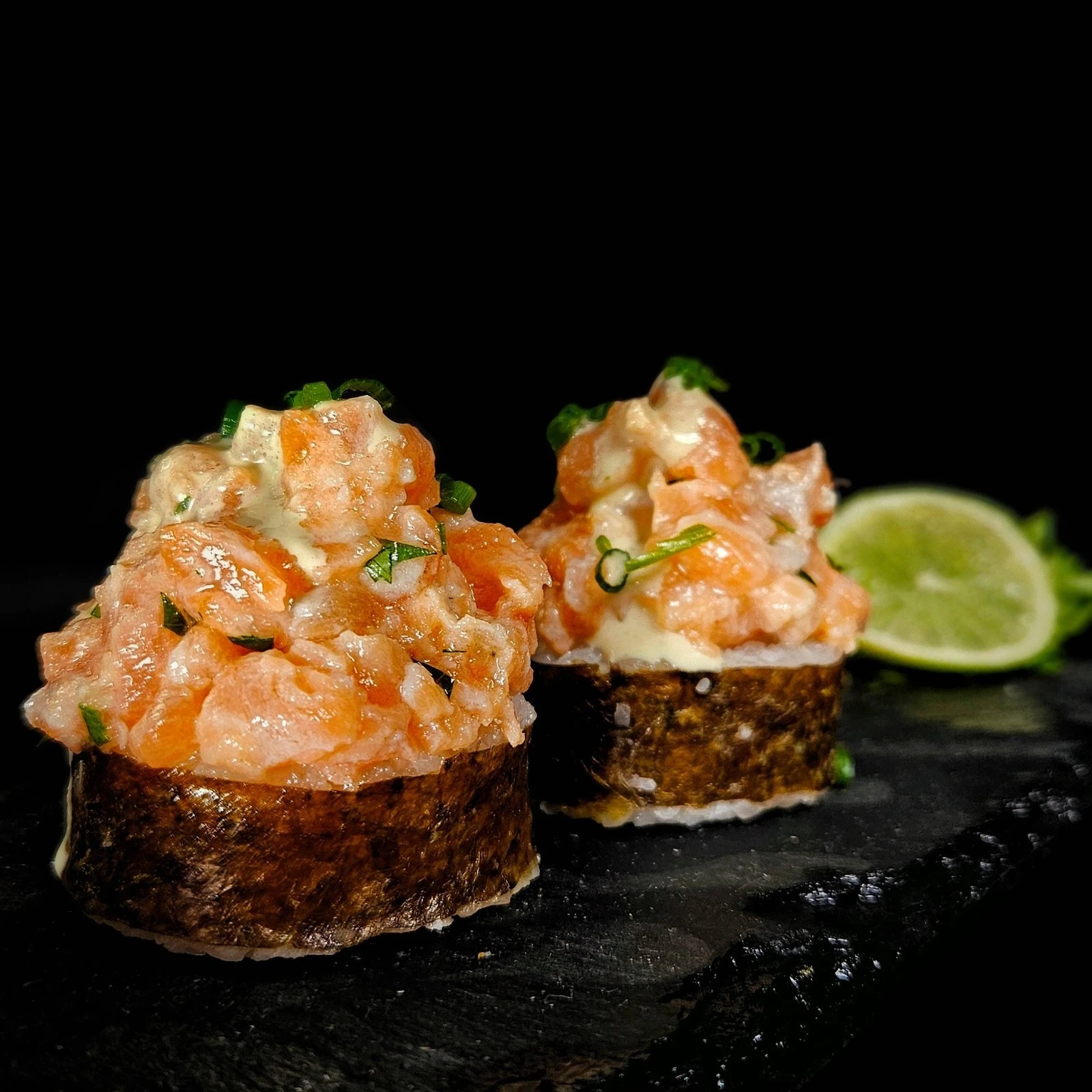 Arroz de sushi envuelto en alga nori, relleno de tartar de salmón fresco.