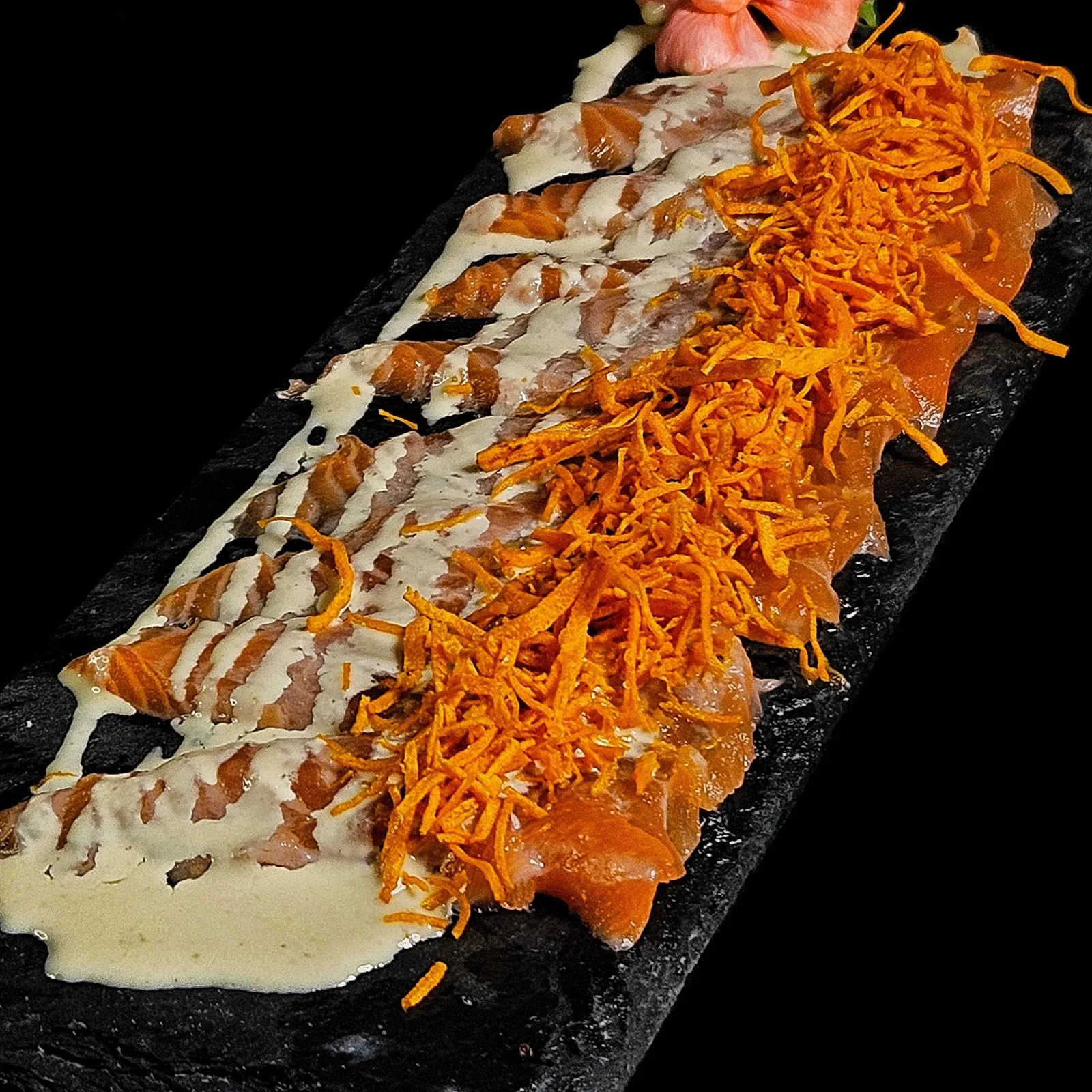 Tiradito de finos cortes de salmón con salsa acevichada y chips de boniato.